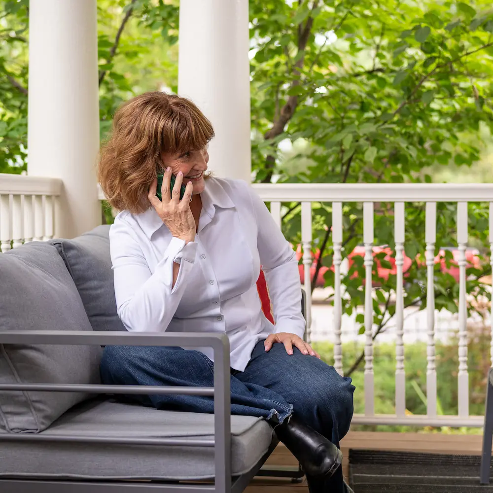 Tracy Sidell on her phone on a North End porch