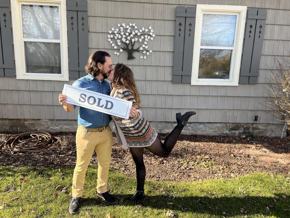 Clients kissing adorably in front of their new Southeast Boise home, after relocating from Texas.